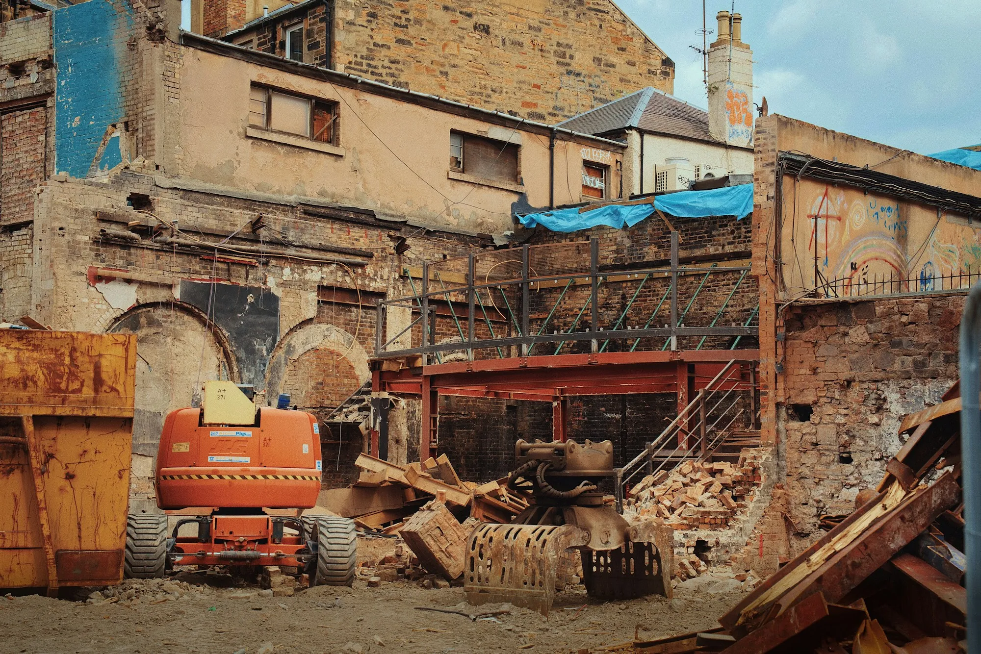 Partly demolished building with equipment on site